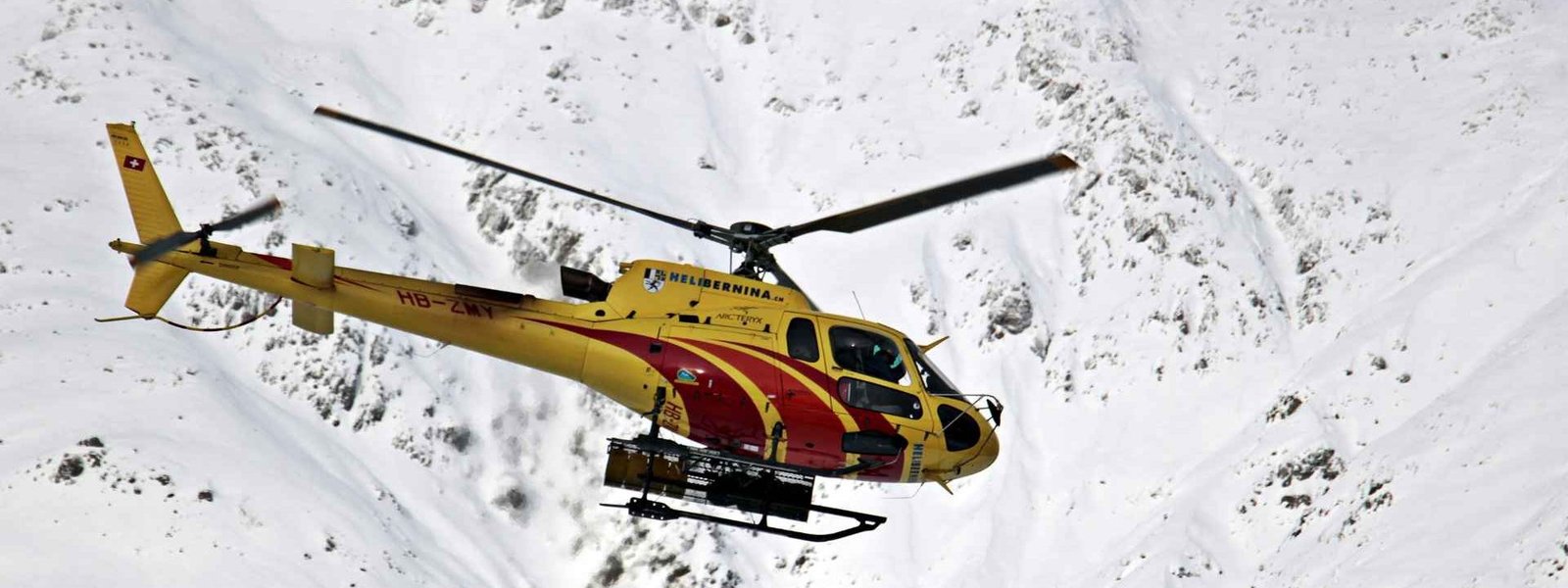 helicopter flying over himalayan mountain range